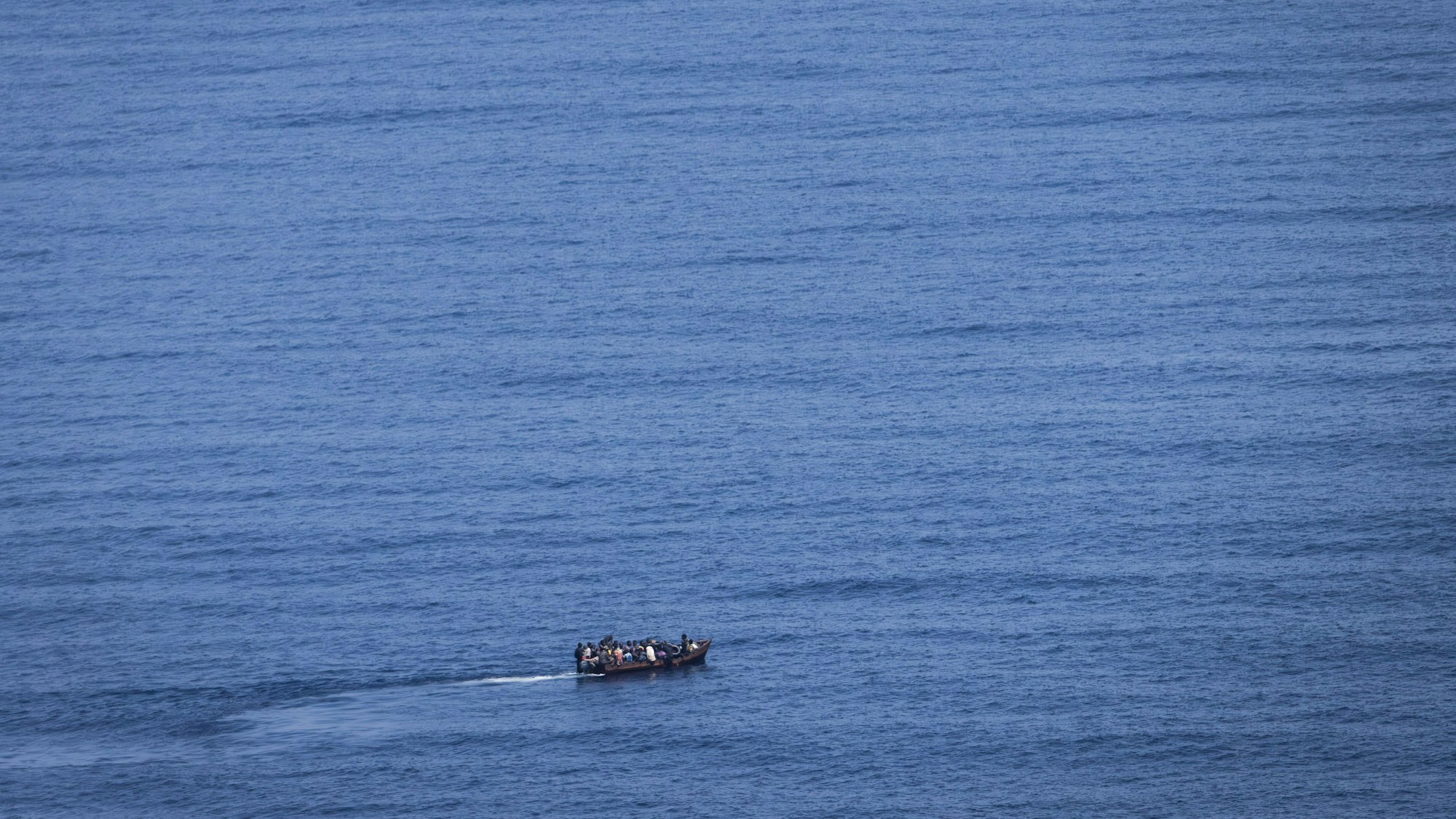 Migranten steuern ein Boot über das Mittelmeer (Symbolbild). Im Atlantik suchen Rettungskräfte nach 200 vermissten Migranten.
