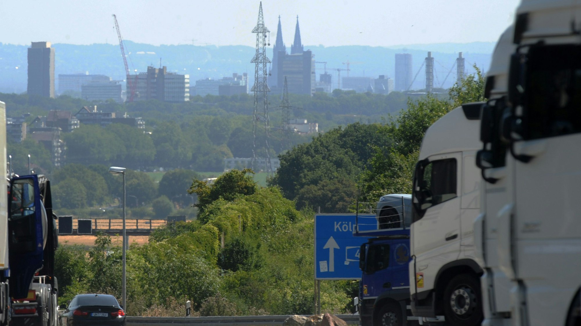 Das Bild zeigt einen Hochspannungsmast vor dem Kölner Dom