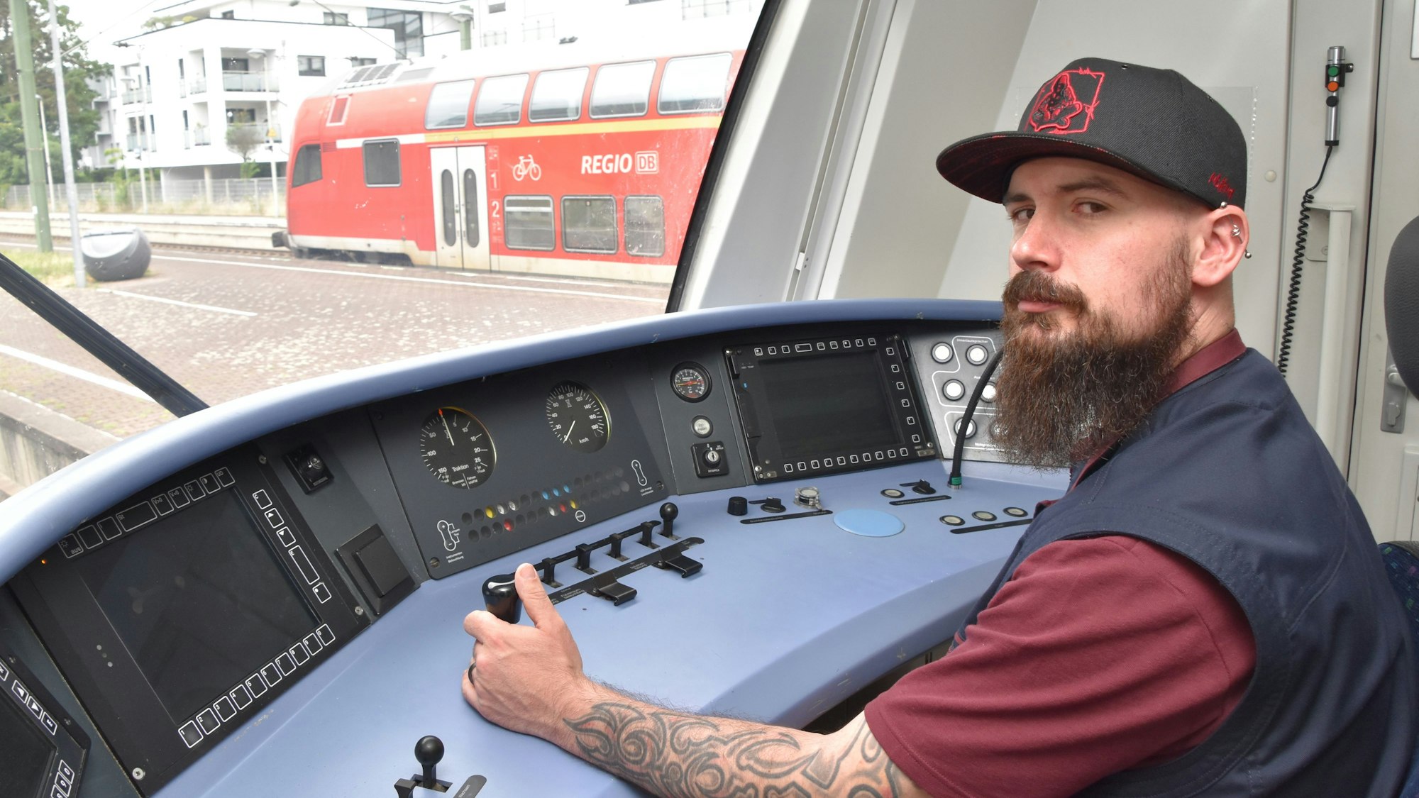 Ein Mann sitzt im Führerstand eines Zuges.