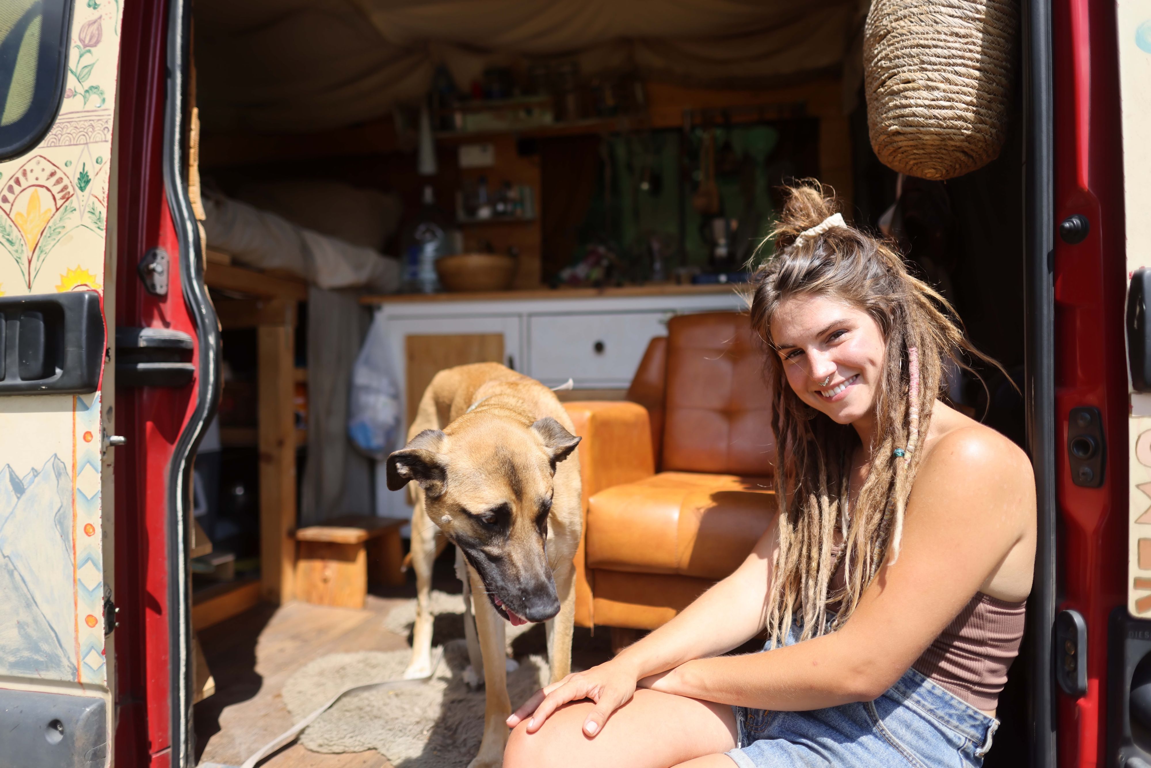 Sarah und ein Hund sitzen in einem ausgebauten Van.