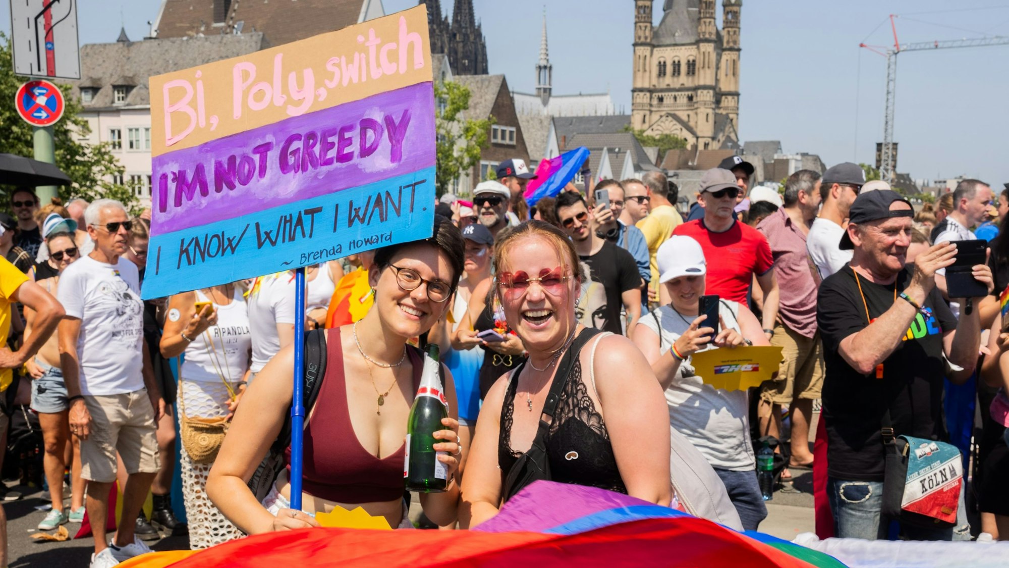 Regenbogenflagge und zwei demonstrierende Frauen.