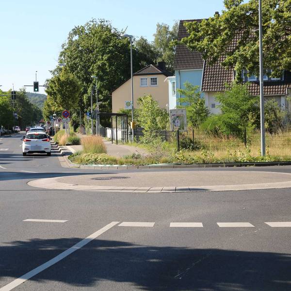 Autos fahren über die Linzer Straße. Im Vordergrund befindet sich der Mini-Kreisel am Floßweg.