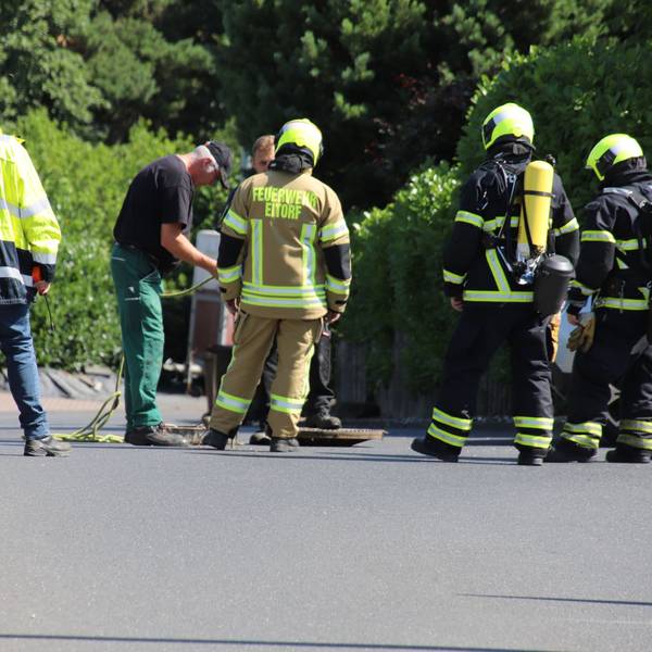 Feuerwehrleute begutachten einen Kanalschacht.