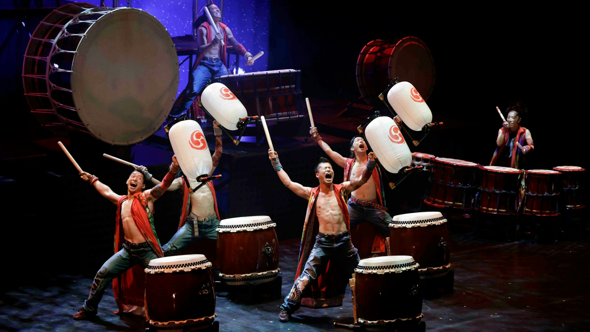 Männer stehen vor großen Trommeln