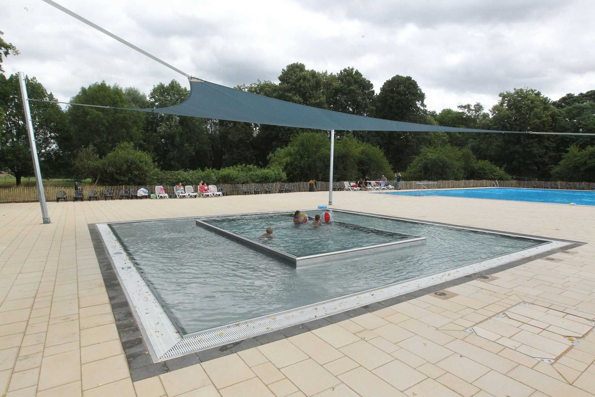 Ein Babybecken wird von einem Sonnensegel vor zuviel UV-Strahlung und Hitze geschützt.