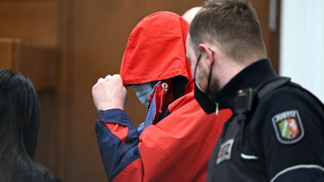 Der angeklagte katholische Priester wird in den Gerichtssaal geführt.