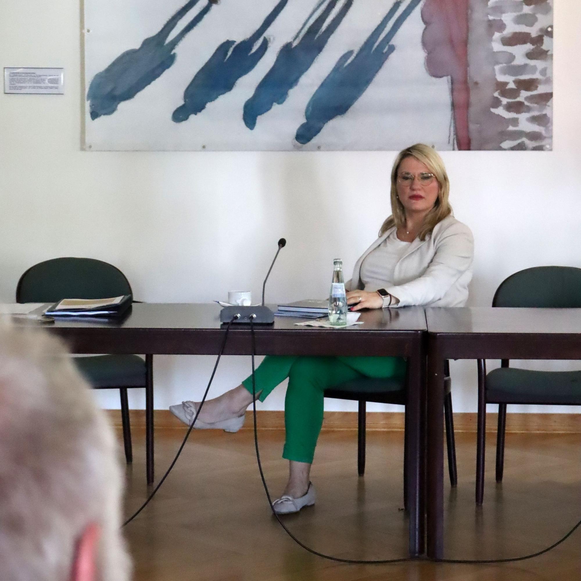 Christina Stumpp sitzt am Tisch im Rats- und Bürgersaal und spricht mit Bernhard Ohlert.