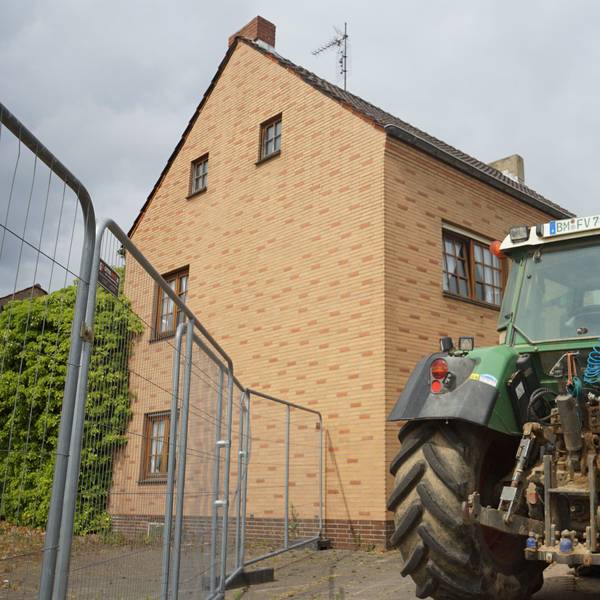 Der letzte Hof in Manheim, vor dem Gebäude steht ein Traktor.
