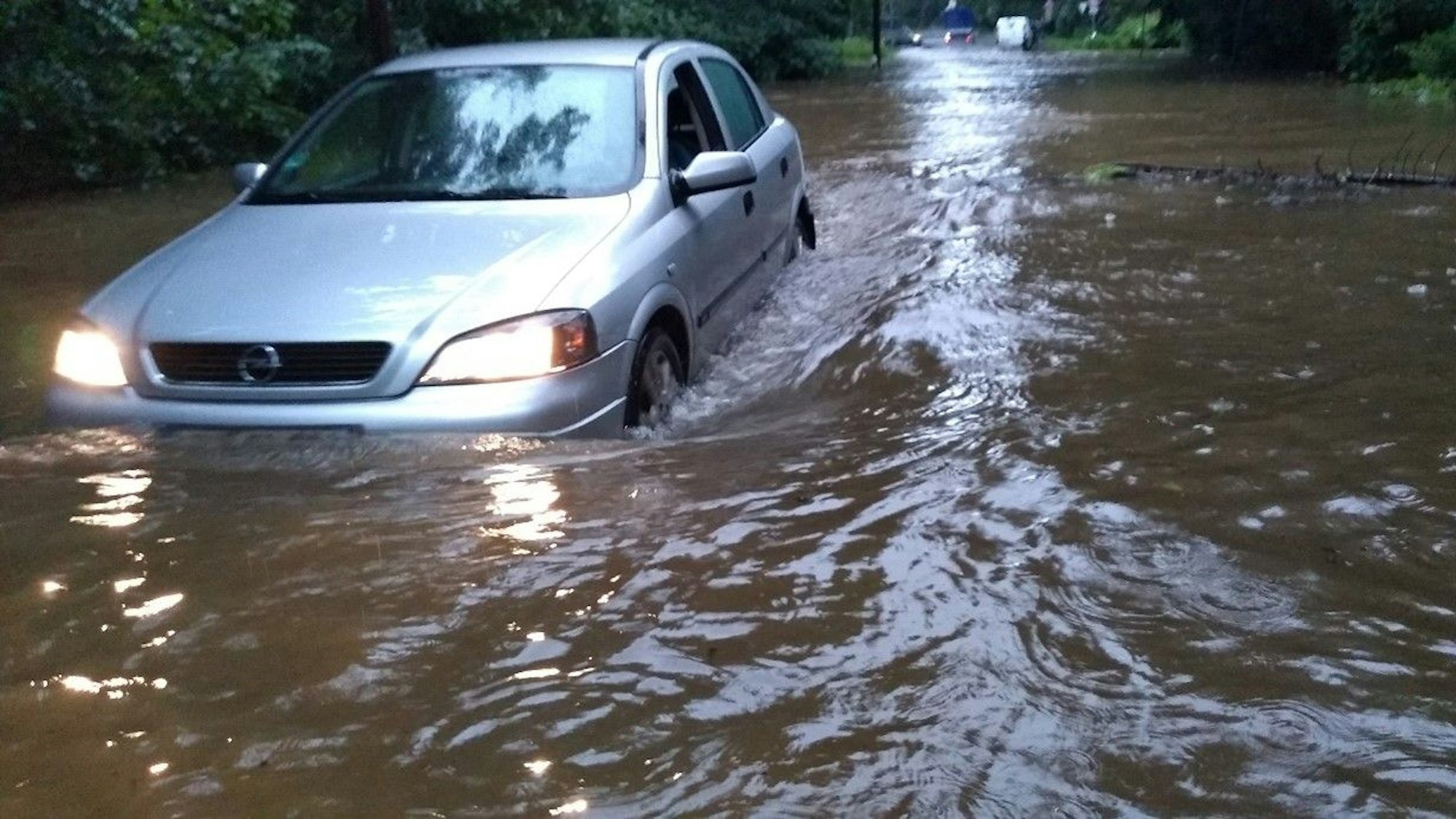 Ein Auto steckt im Hochwassers in Dünnwald fest.