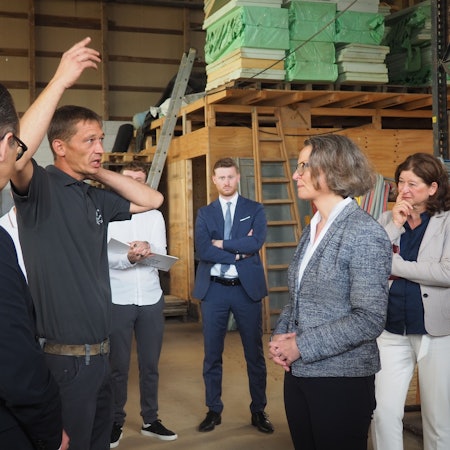 Das Bild zeigt NRW-Ministerin Ina Scharrenbach im Gespräch mit dem dem Bauunternehmer Bastian Boße.