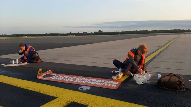 Mitglieder der Letzten Generation haben sich am Donnerstagmorgen (13. Juli) auf einer Zufahrtsstraße zur Start- und Landebahn am Flughafen Düsseldorf festgeklebt und so den Flugbetrieb gestört.