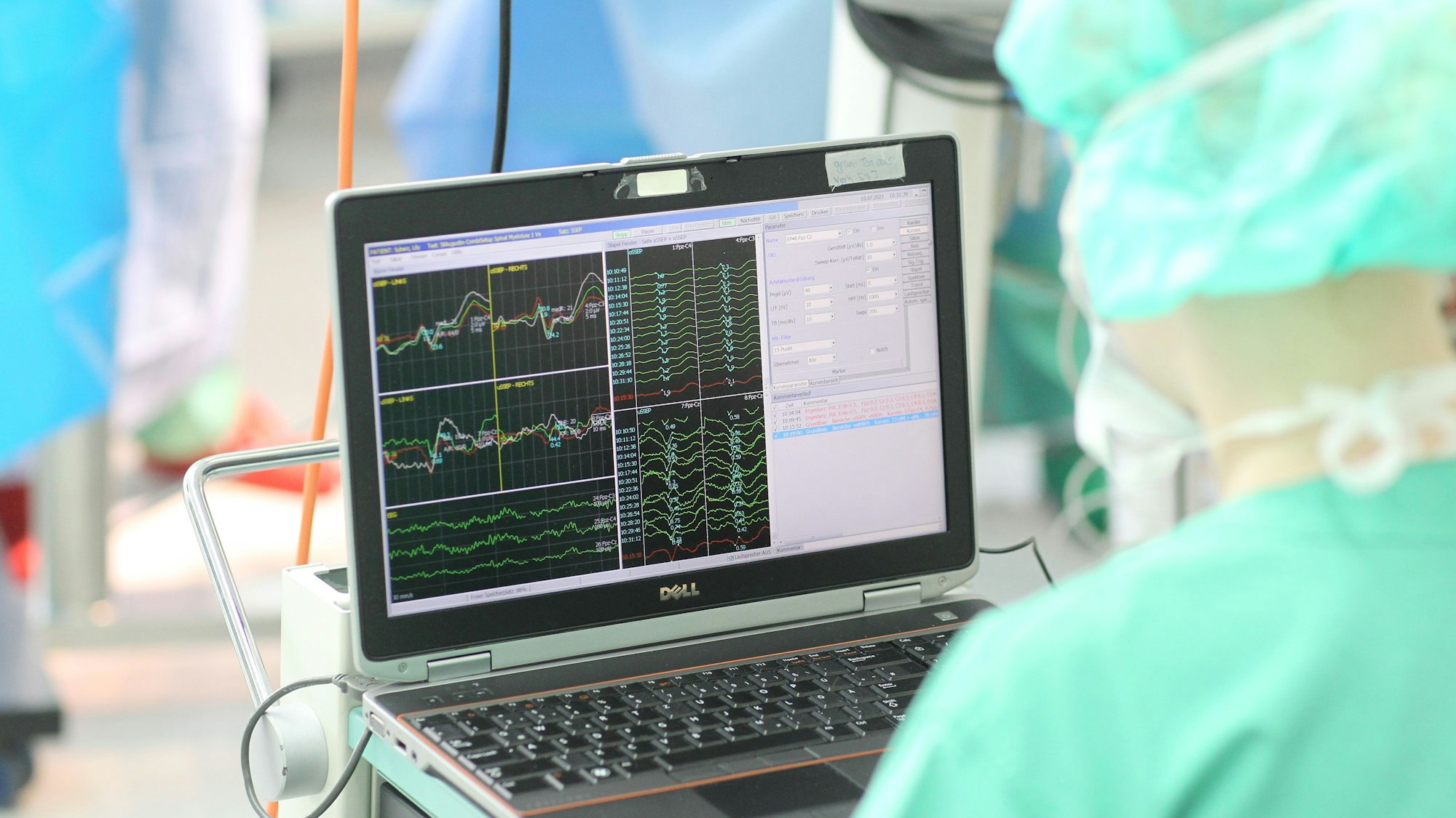 Ein Krankenpfleger sitzt am Computer und kontrolliert am Bildschirm die Funktionen aller wichtigen Nervenbahnen.