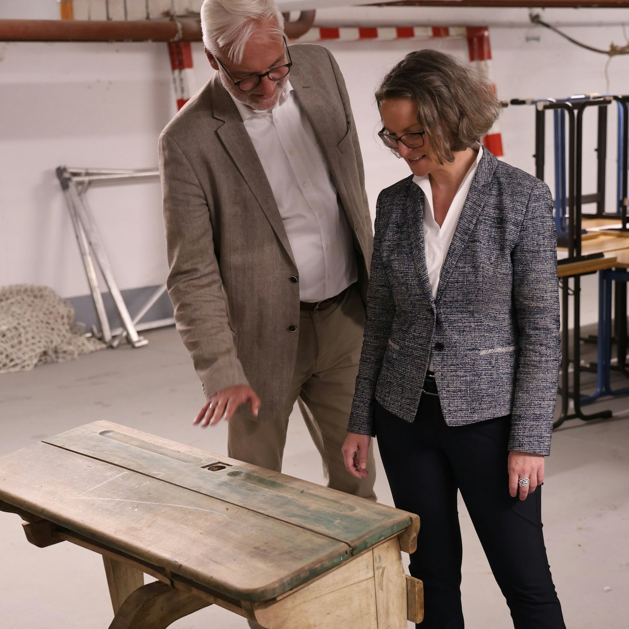 Die beiden Besucher betrachten das alte Pult.