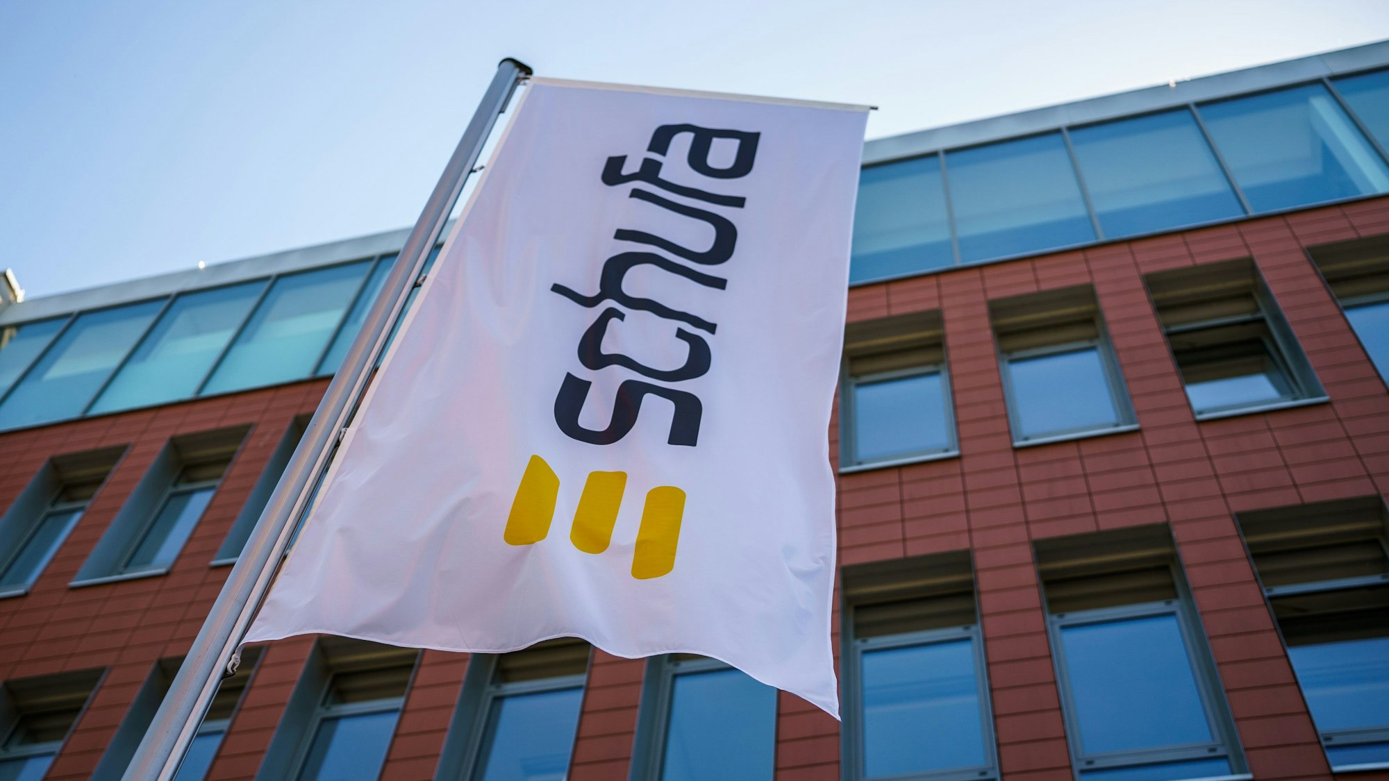 Eine Flagge mit dem Firmenlogo flattert vor dem Geschäftssitz in der Landeshauptstadt.