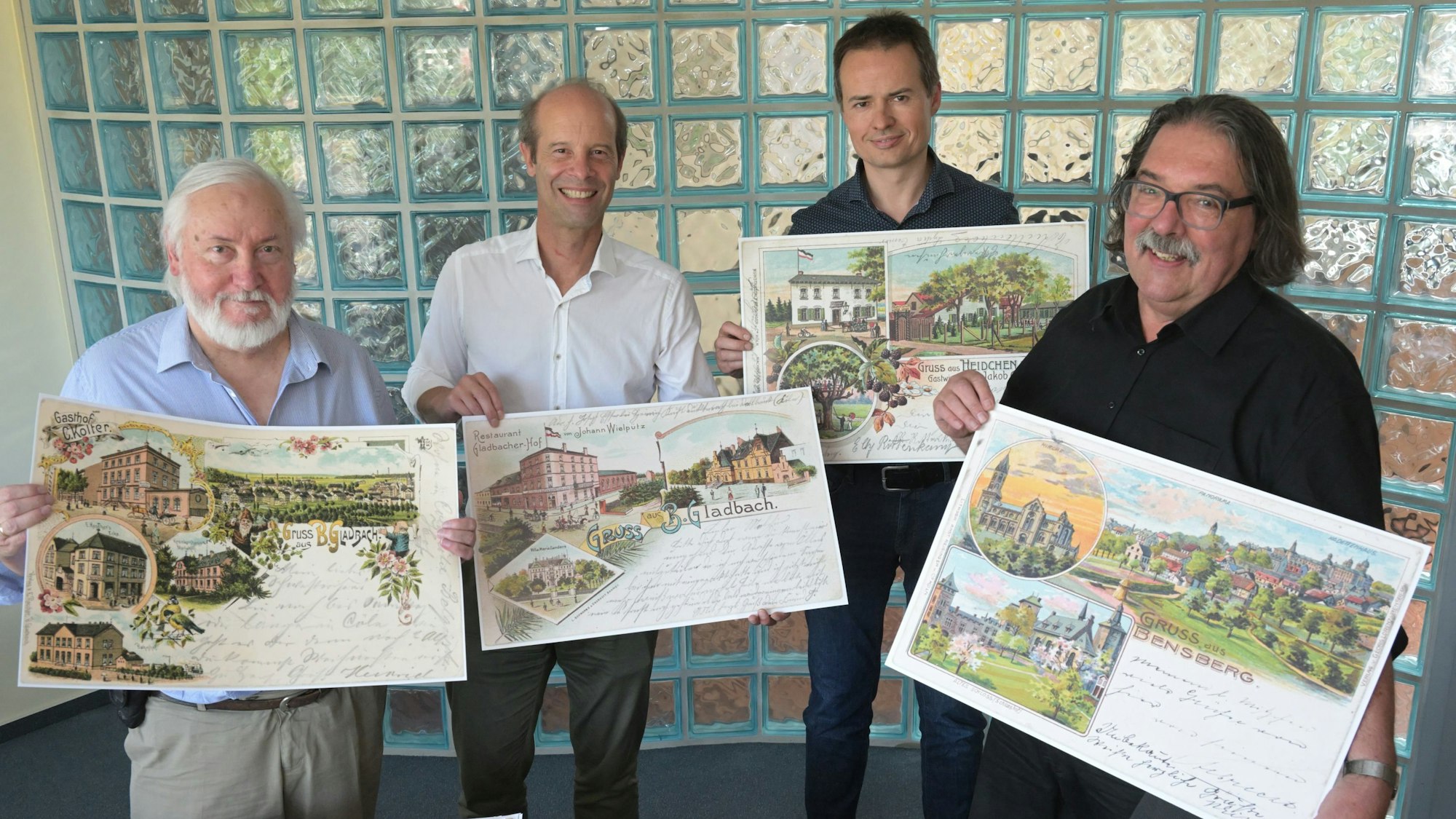 Peter Lückerath, Hans Martin Heider, Thomas Schwabach und Michael Werling (v.l.) zeigen alte Ansichtskarten von Bergisch Gladbach, die in einem Buch veröffentlicht werden sollen.
