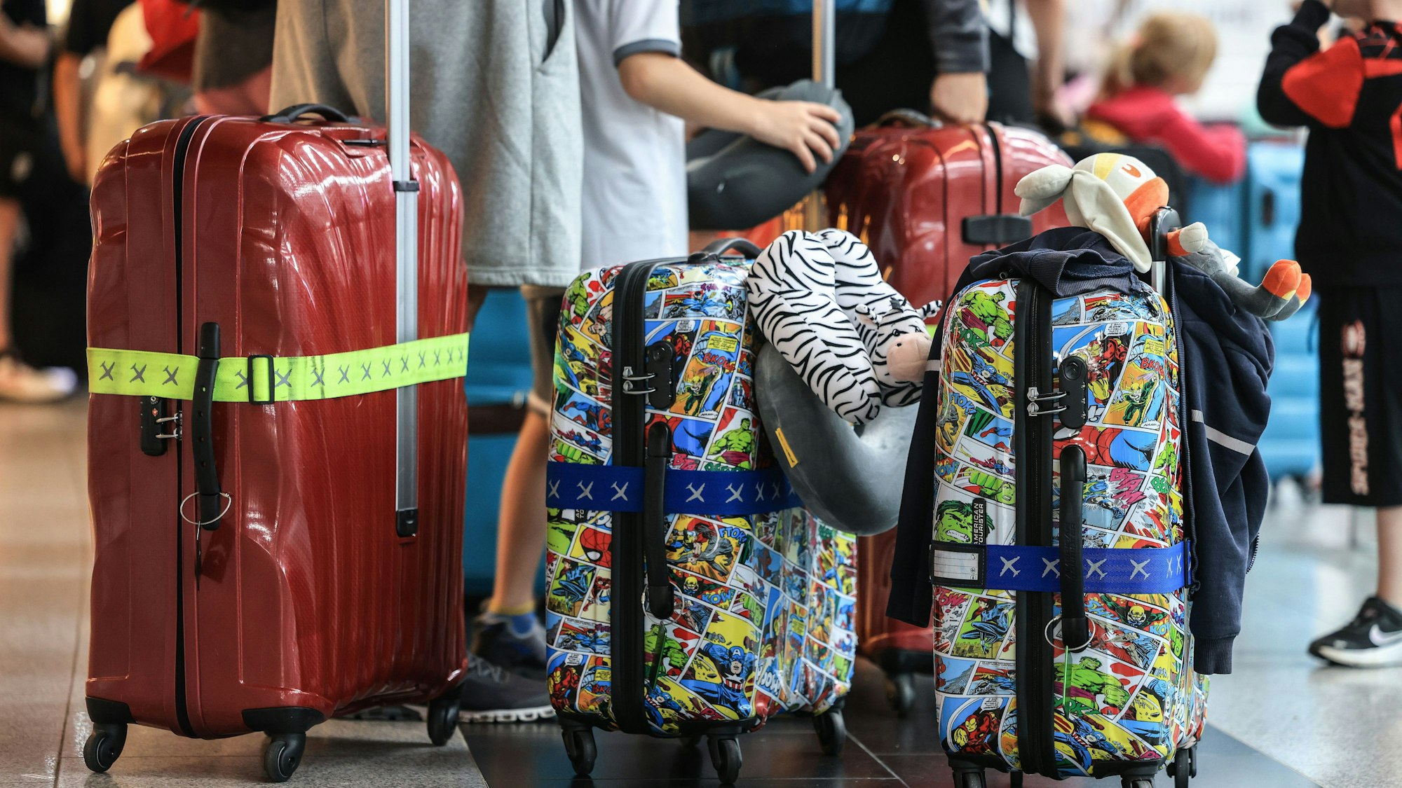 22.06.2023, Nordrhein-Westfalen, Düsseldorf: Reisende stehen am Flughafen Düsseldorf in einer Warteschlange.
