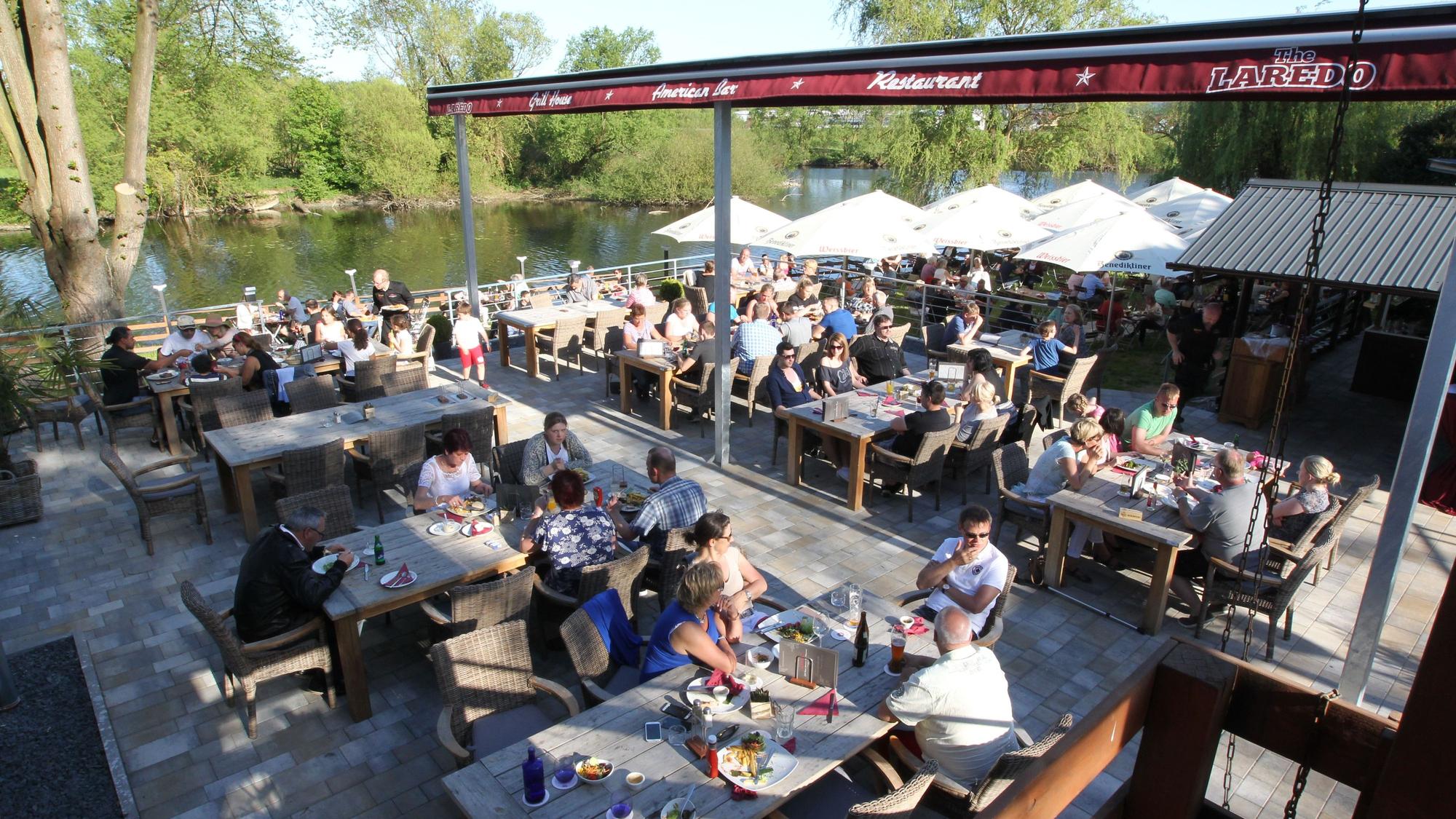 Menschen sitzen in einem Biergarten.