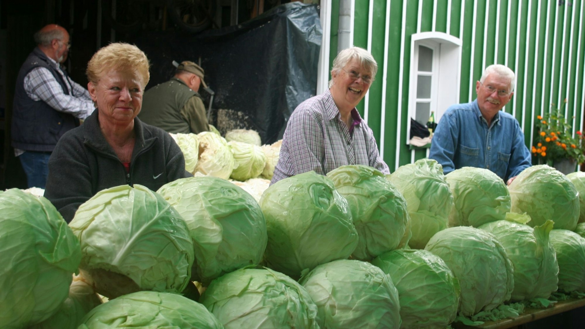 Christine Weber vor einer Reihe gestapelter Weißkohlköpfe.