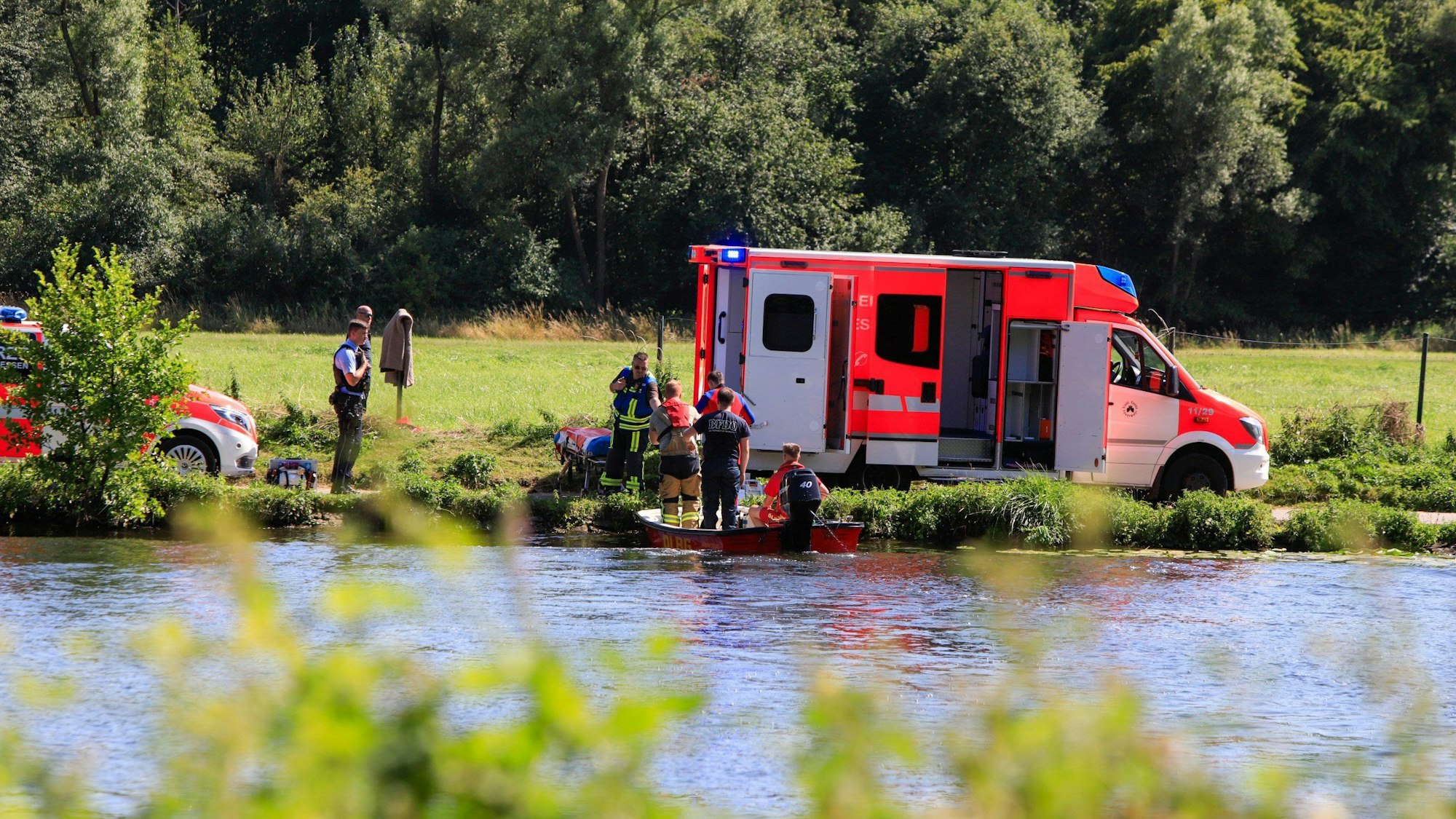 Ein Krankenwagen steht am Fluss.