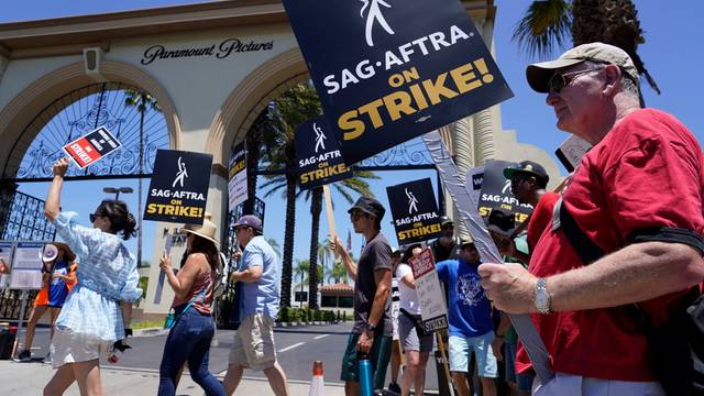 14.07.2023, USA, Los Angeles: Streikende Drehbuchautoren und Schauspieler streiken vor den Paramount-Studios. Nach mehr als 60 Jahren streiken die Schauspieler und Drehbuchautoren in den USA erstmals wieder gemeinsam und dürften den Betrieb in Hollywood auf unbestimmte Zeit lahmlegen. Foto: Chris Pizzello/AP/dpa +++ dpa-Bildfunk +++