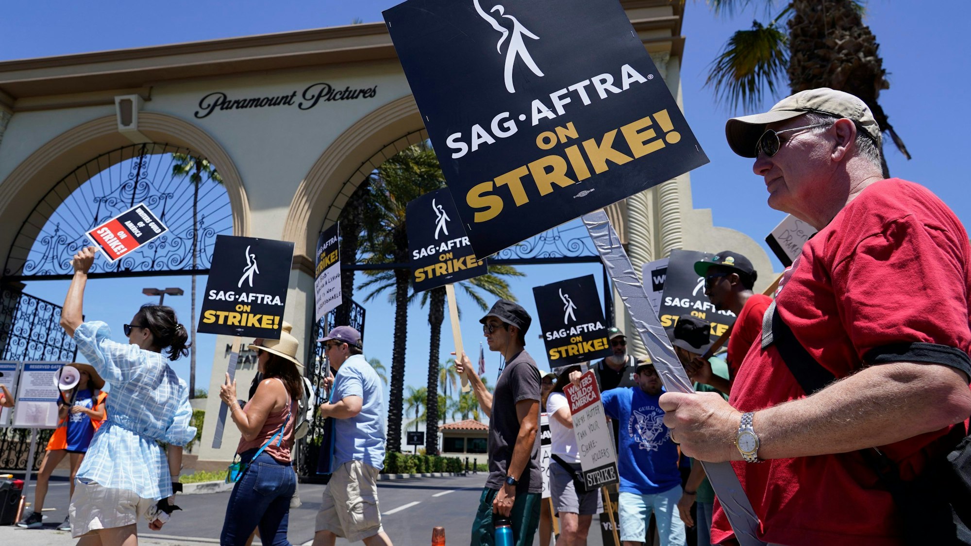 14.07.2023, USA, Los Angeles: Streikende Drehbuchautoren und Schauspieler streiken vor den Paramount-Studios. Nach mehr als 60 Jahren streiken die Schauspieler und Drehbuchautoren in den USA erstmals wieder gemeinsam und dürften den Betrieb in Hollywood auf unbestimmte Zeit lahmlegen. Foto: Chris Pizzello/AP/dpa +++ dpa-Bildfunk +++