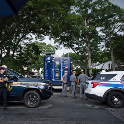 Polizisten in der Nähe des Hauses, in dem der Verdächtige in der lange ungelösten Mordserie festgenommen wurde.