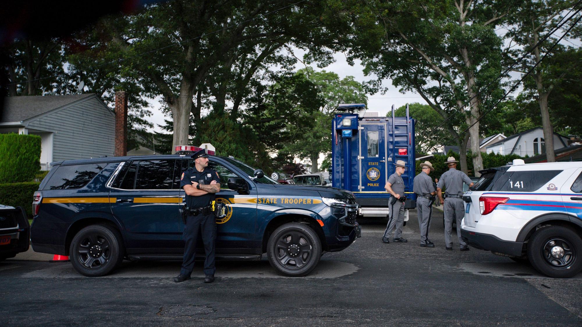 Polizisten in der Nähe des Hauses, in dem der Verdächtige in der lange ungelösten Mordserie festgenommen wurde.