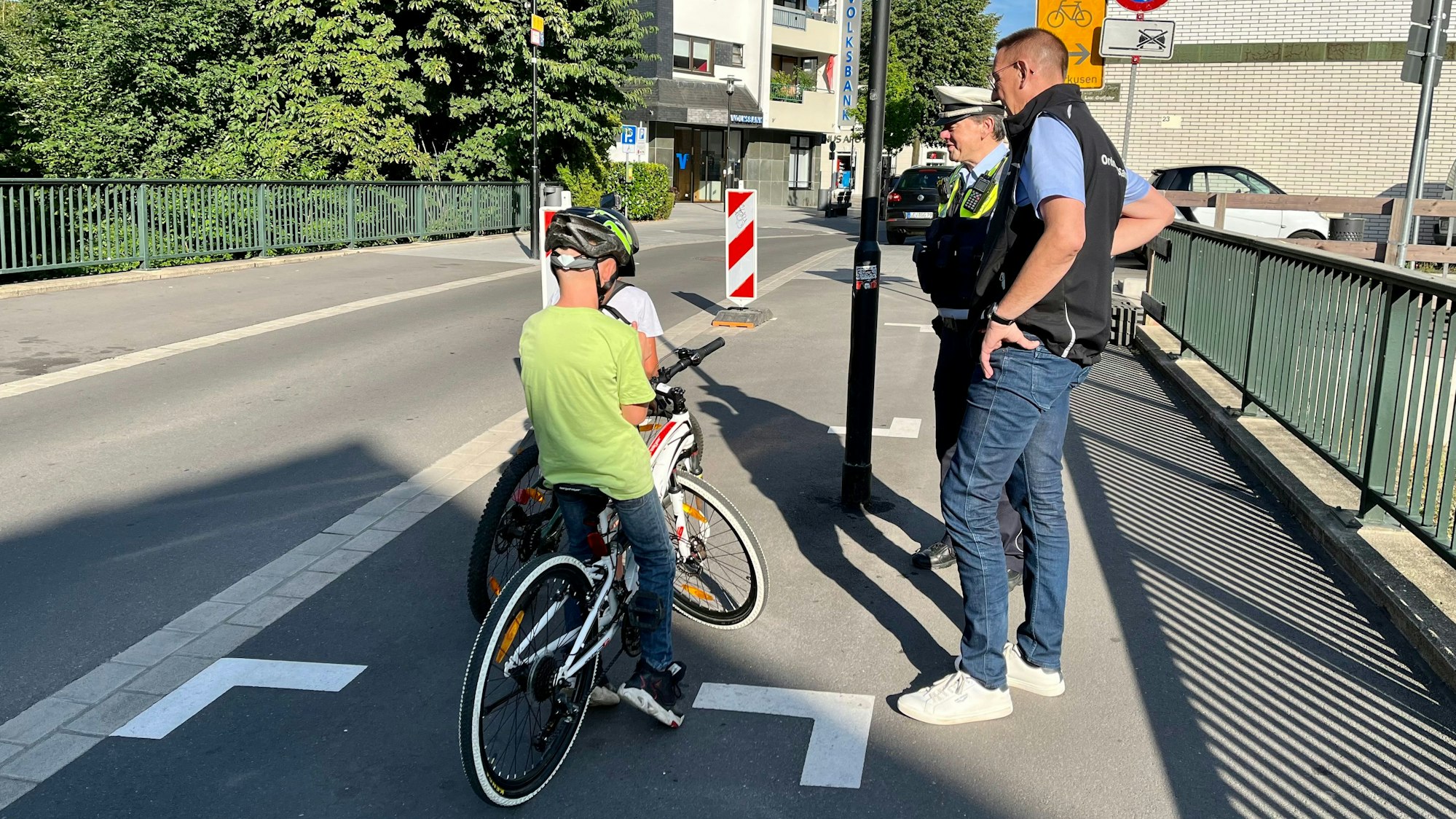 Polizist Andreas Weidemann und Bürgermeister Dirk Runge mit zwei Jungs auf dem Rad