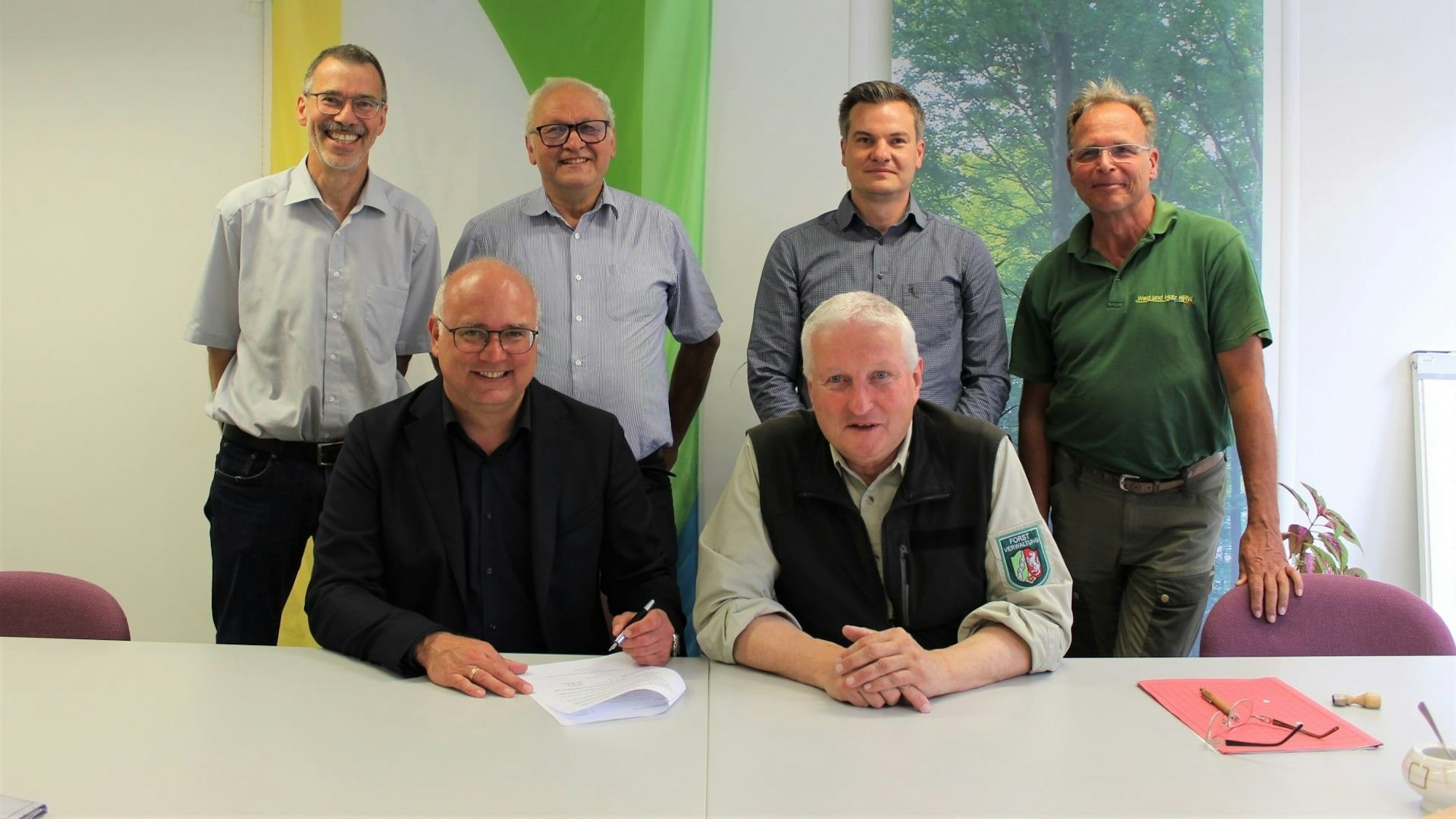 Gruppenfoto mit zwei sitzenden und vier dahinter stehenden Männern.