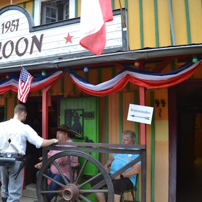 Männer stehen vor einem Wildwest-Saloon.