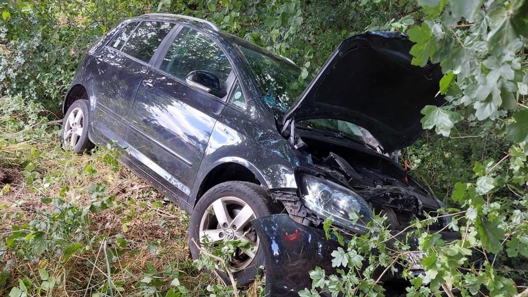 Ein Auto liegt in der Böschung.