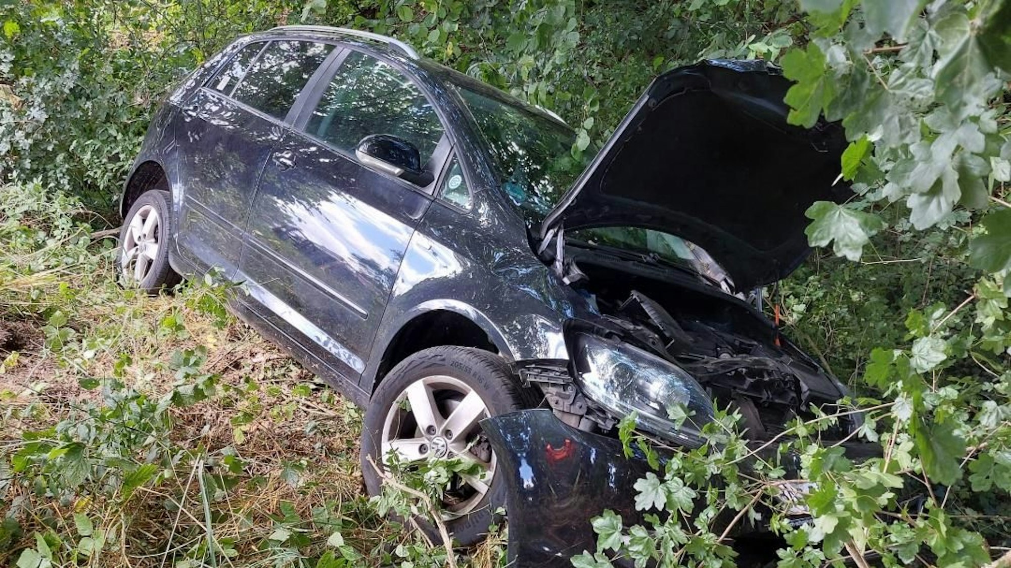 Ein Auto liegt in der Böschung.