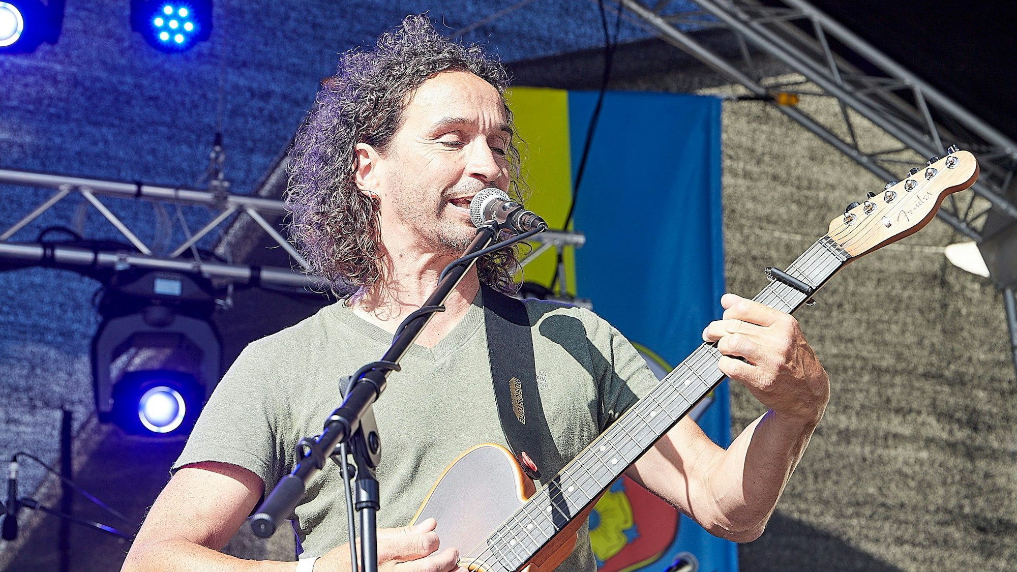 Ein Musiker spielt Gitarre und singt.