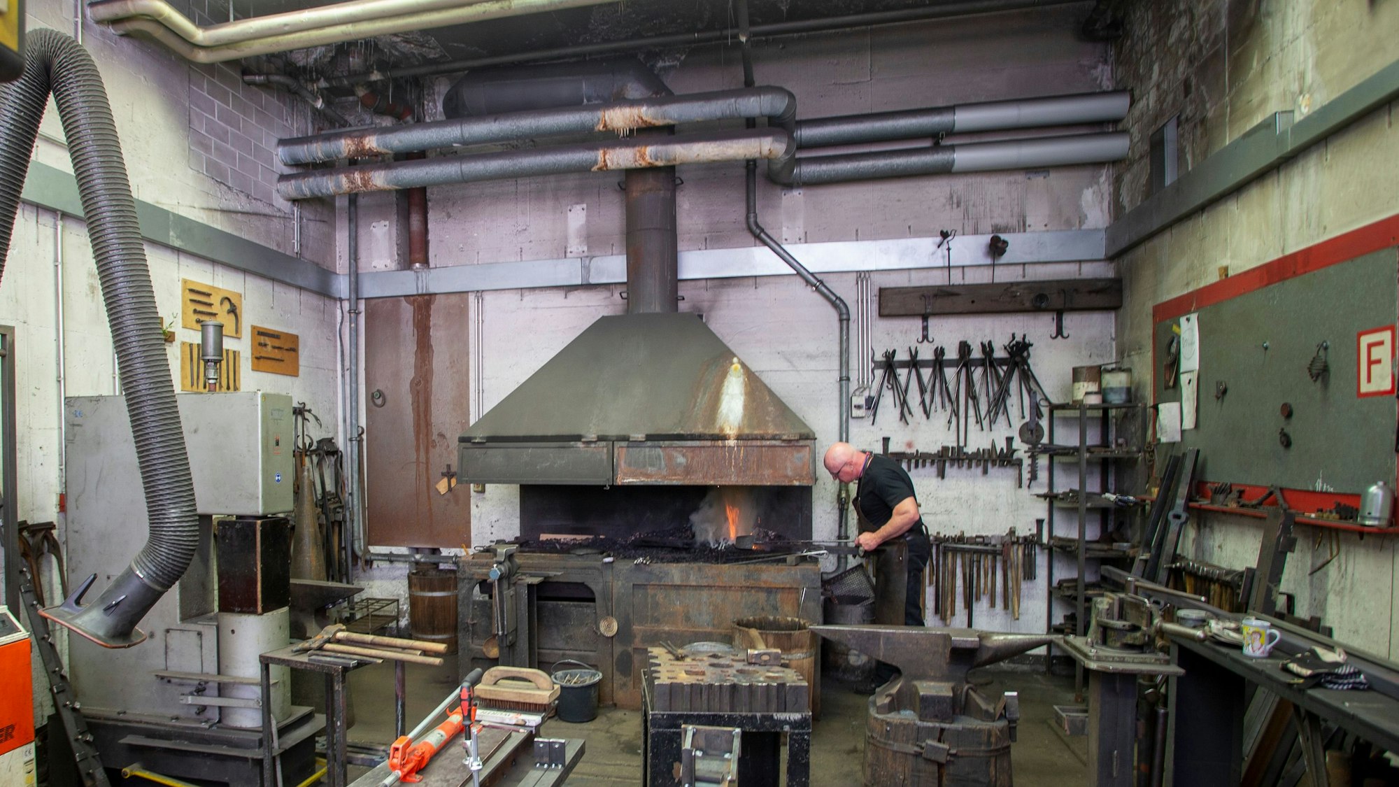 Ein seltener Blick in die Schmiede der Dombauhütte. An den Rohren oberhalb des Ofens ist klar zu erkennen, wo das Wasser von der Decke auf das Metall tropft.