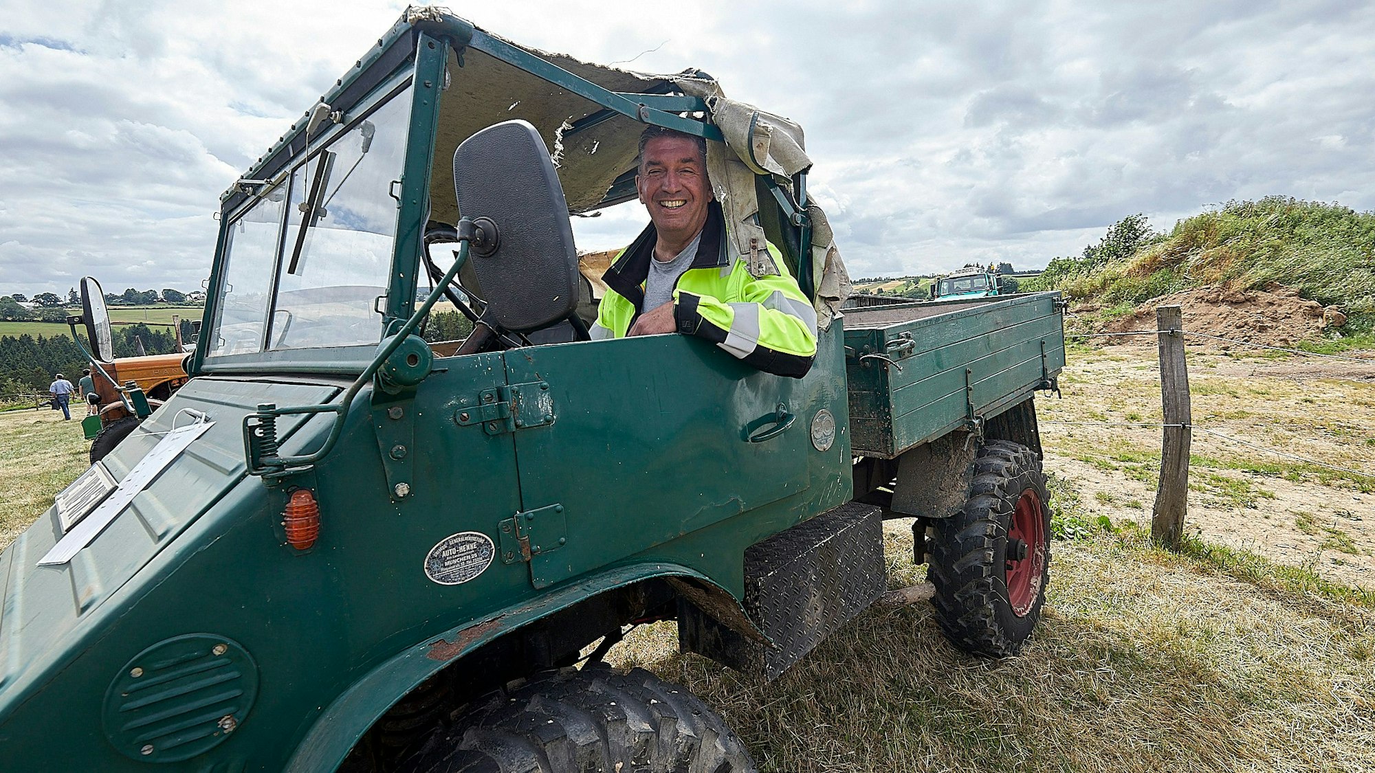 Ein Mann sitzt in seinem grünen Unimog, der 1961 gebaut wurde.