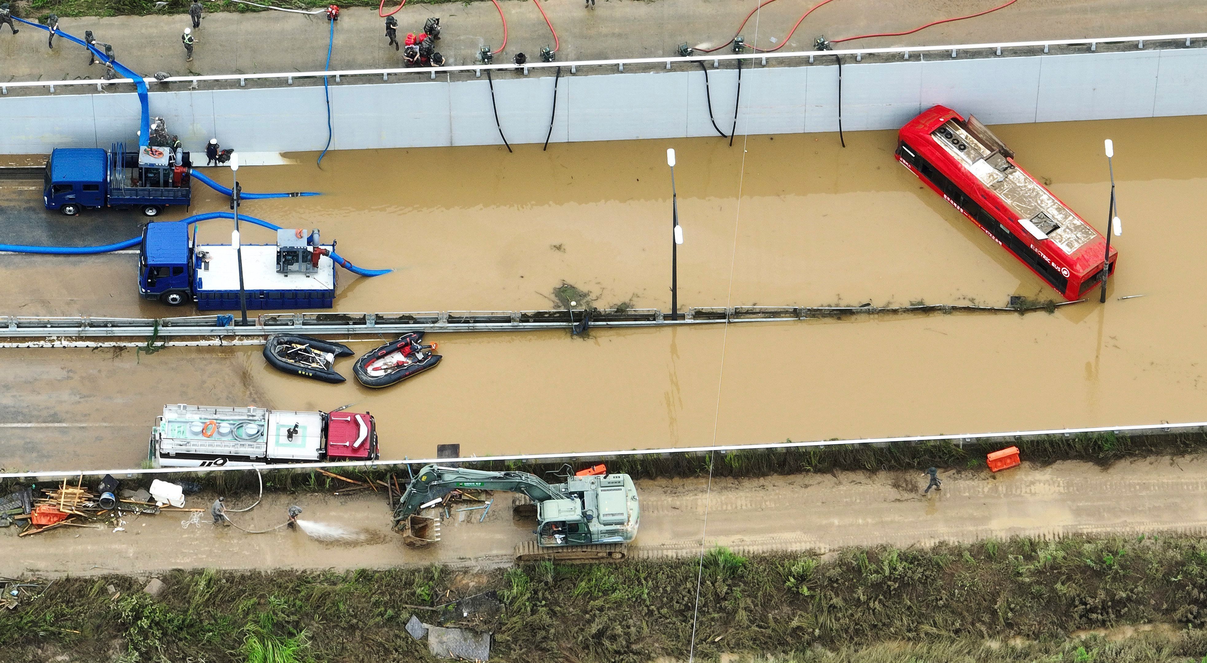 Rettungskräfte suchen nach Überlebenden auf einer Straße, die von Fluten überschwemmt wurde und zu einem unterirdischen Tunnel führt. Nach massiven Regenfällen und Überschwemmungen sind in Südkorea mehrere Menschen ums Leben gekommen.