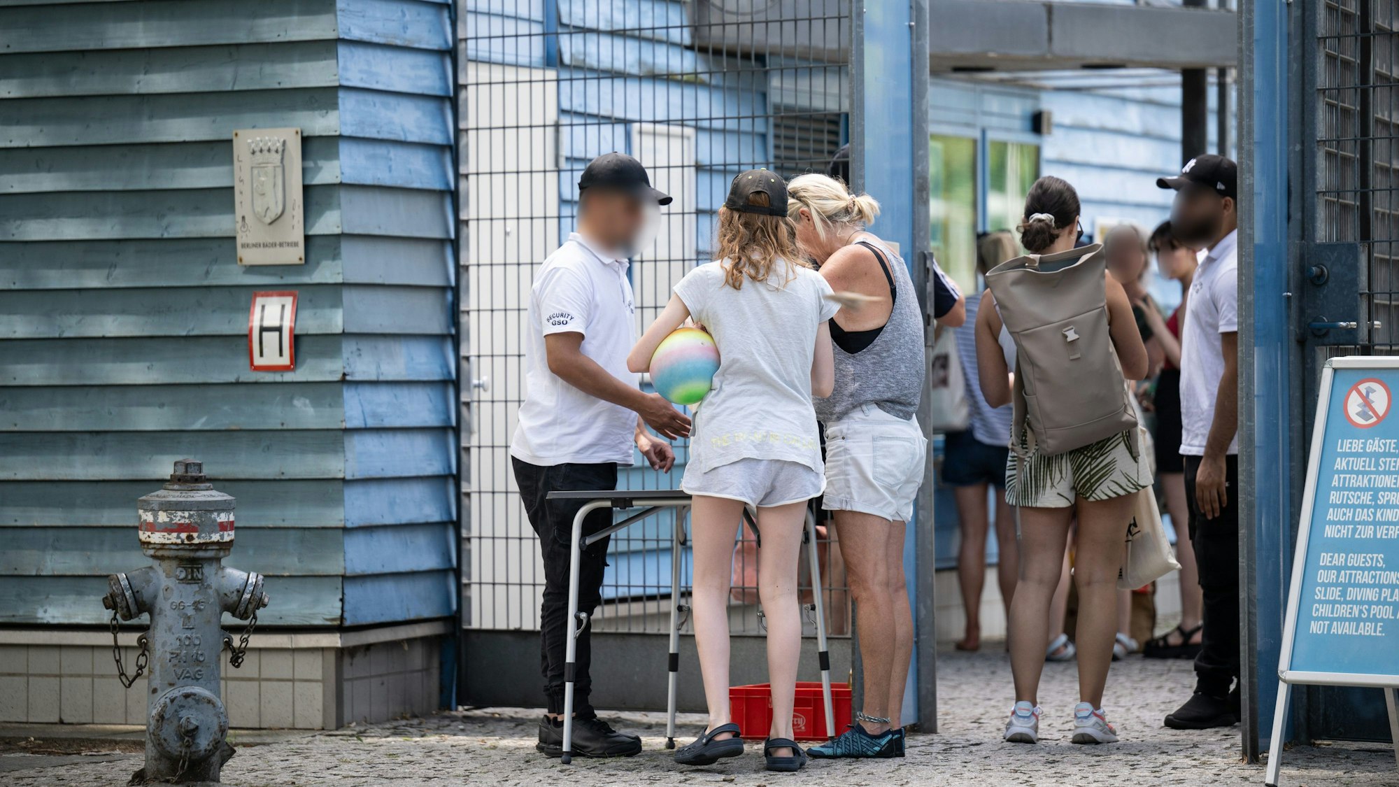 Besucher des Sommerbades Neukölln am Columbiadamm werden am Eingang von Sicherheitspersonal kontrolliert.