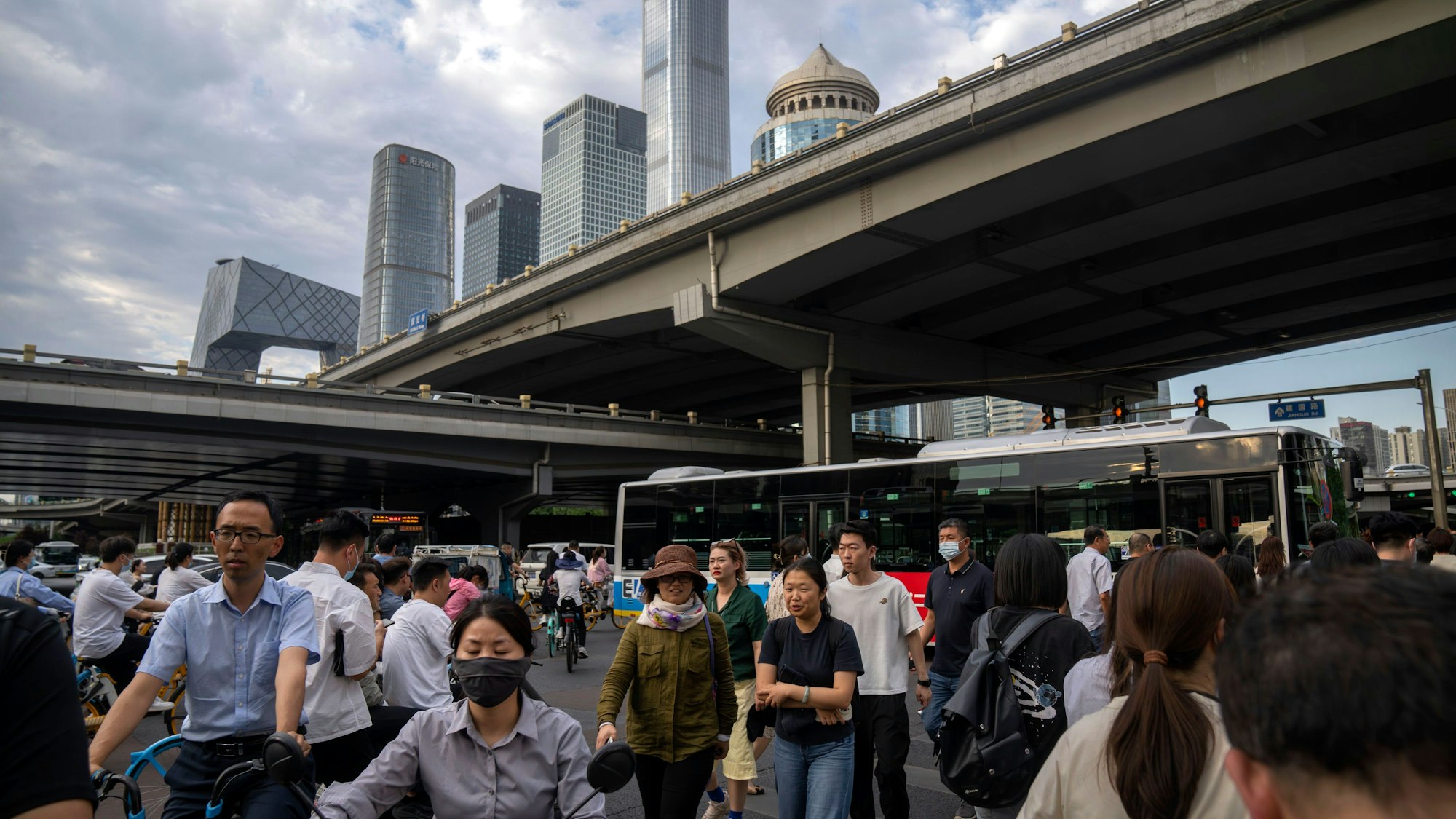 Pendler überqueren am 13. Juni 2023 während der abendlichen Rushhour eine Kreuzung im zentralen Geschäftsviertel von Peking.