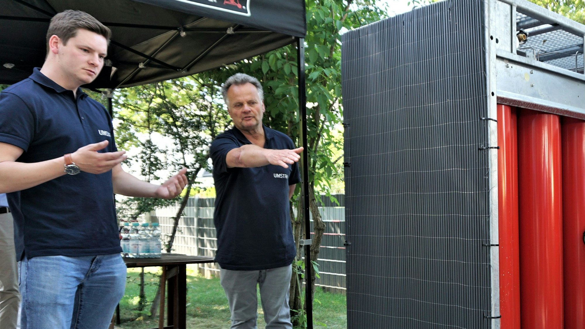 Zwei Männer stehen vor Tanks, die mit Wasserstoff gefüllt sind.