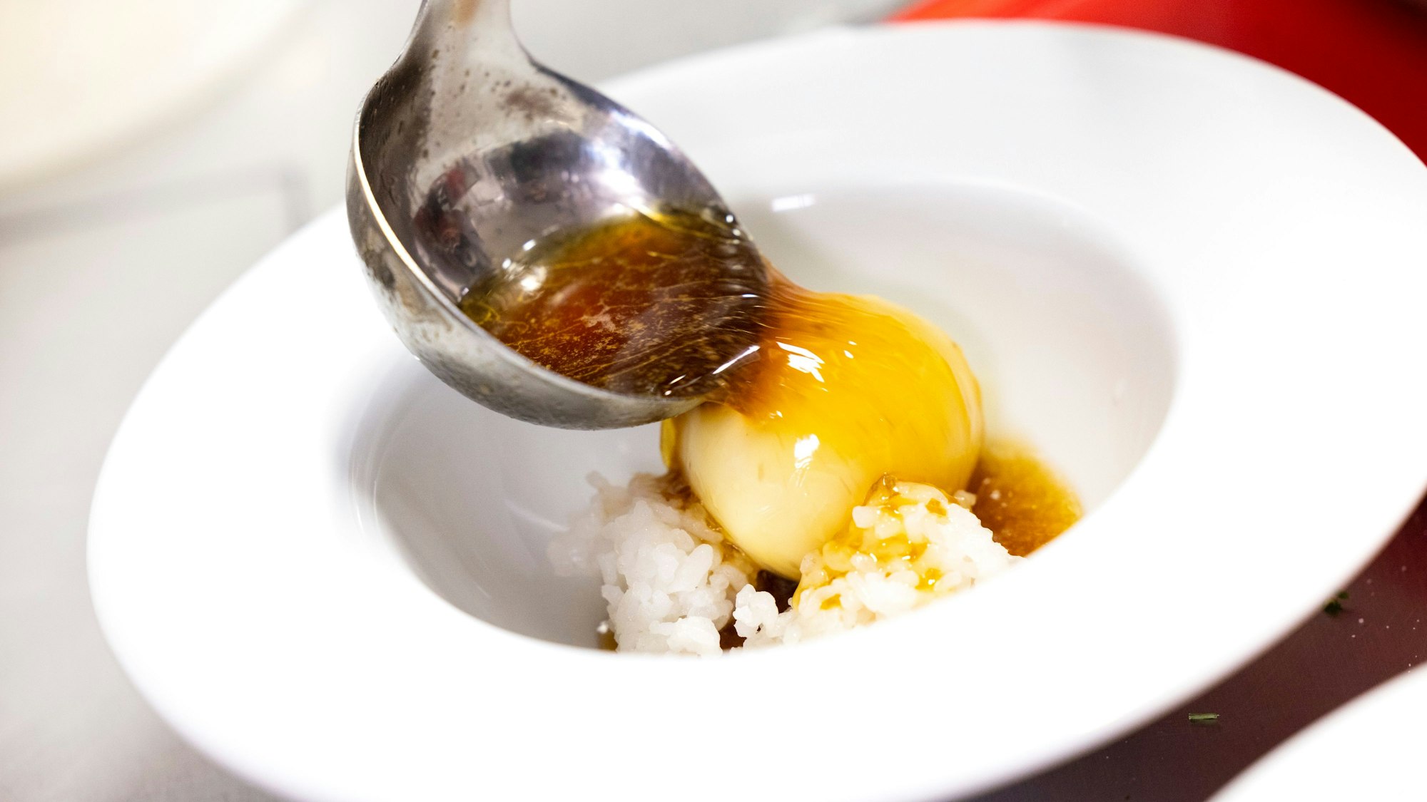 Maximilian Lorenz gibt die Brühe über das gekochte Ei und den Reis.