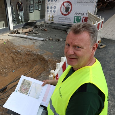 Der Grabungsleiter mit Unterlagen am Rande der Baugrube.