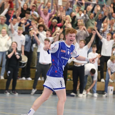 Jugendhandballer Julius Hein läuft jubelnd im Trikot des VfL Gummersbach die vollbesetzten Räng der Schwalbe-Arena entlang.