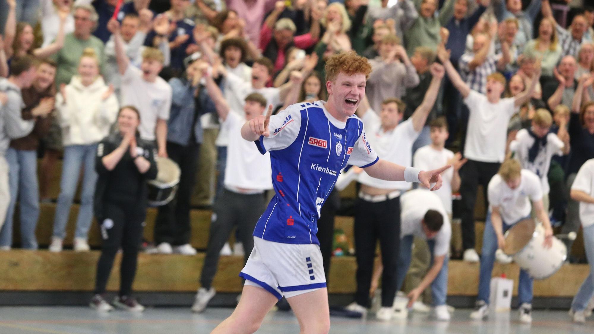Jugendhandballer Julius Hein läuft jubelnd im Trikot des VfL Gummersbach die vollbesetzten Räng der Schwalbe-Arena entlang.