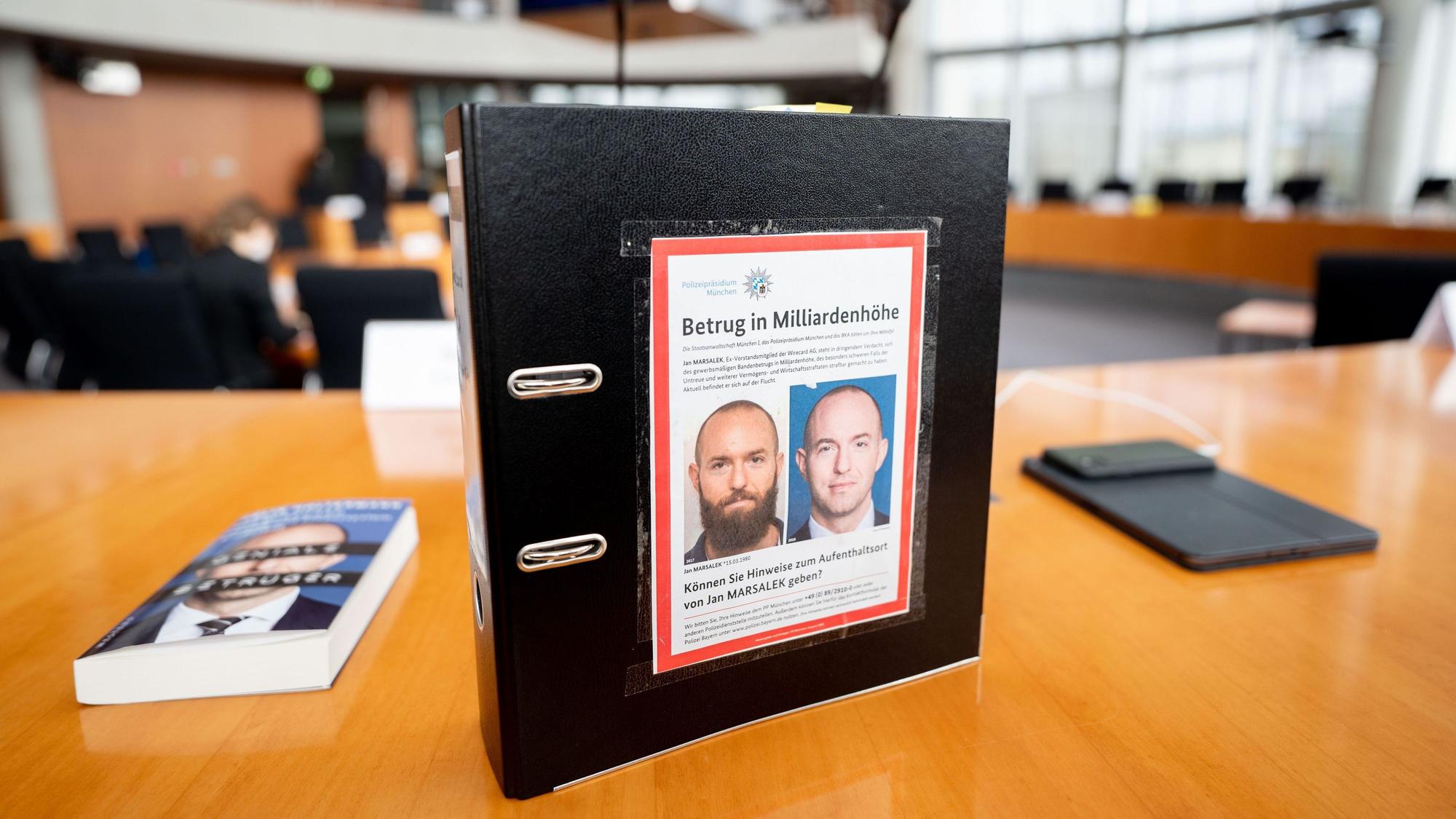 Ein Aktenordner mit Fahndungsfotos von Ex-Wirecard-Manager Jan Marsalek