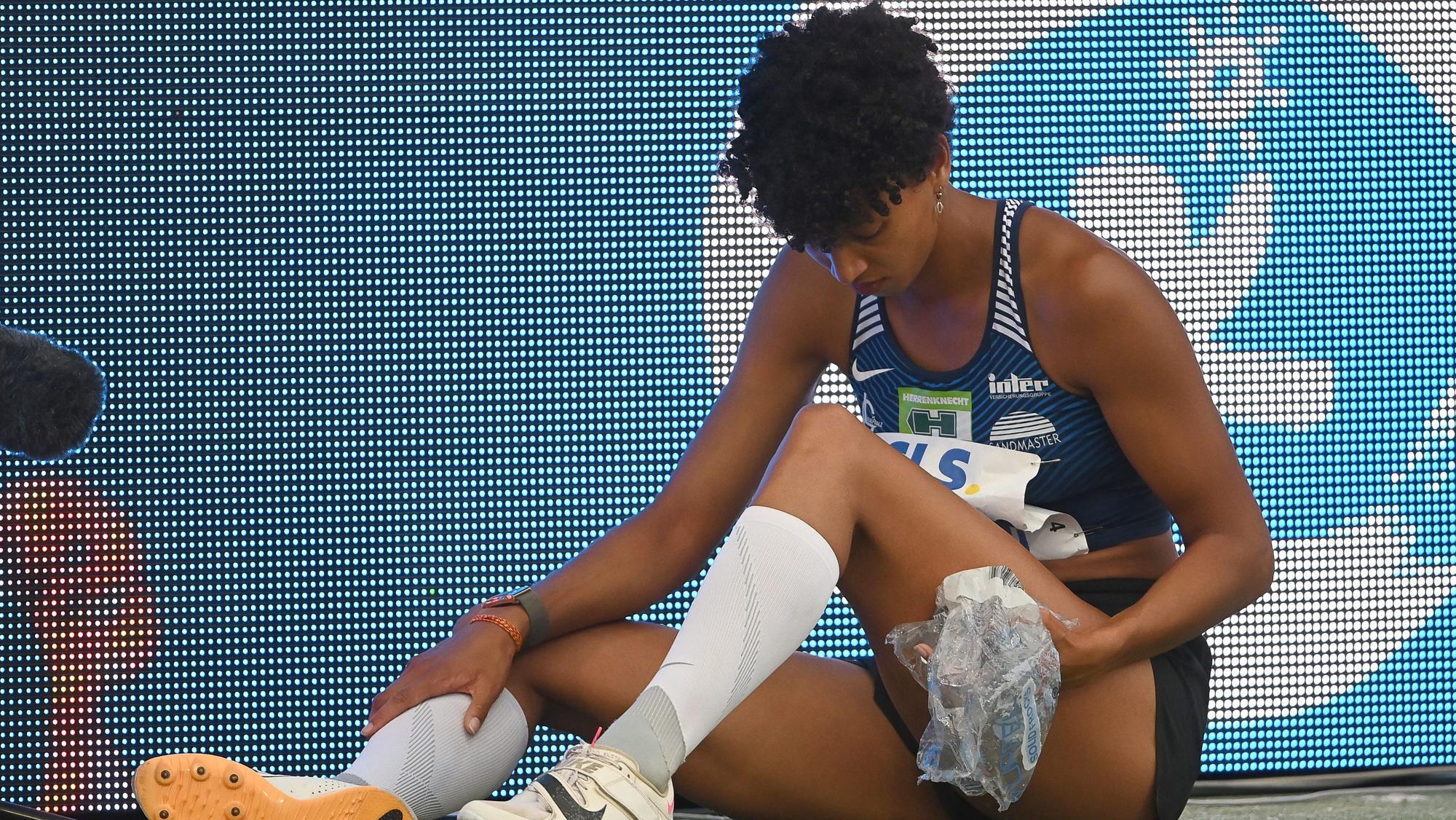 Malaika Mihambo sitzt mit Eis auf dem Boden.