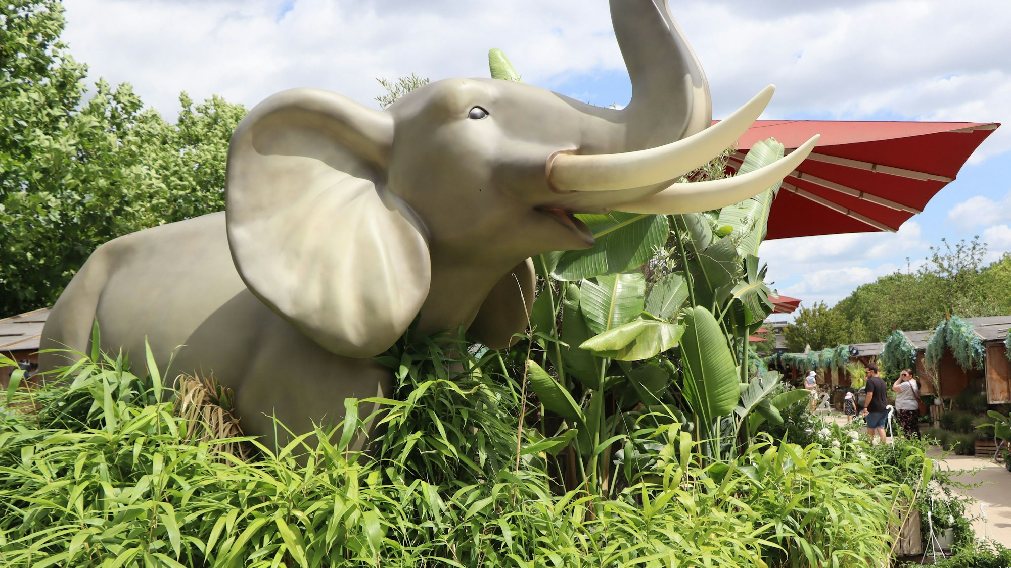 Ein künstlicher Elefant steht im Grünen.