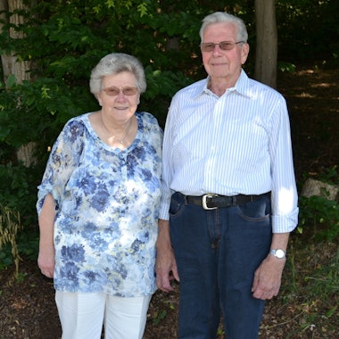 Ein älteres Ehepaar steht im Grünen nebeneinander.