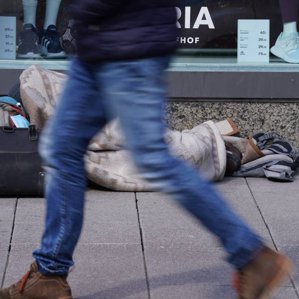 AEin Obdachloser liegt vor einem Schaufenster von Galeria Karstadt Kaufhof.
