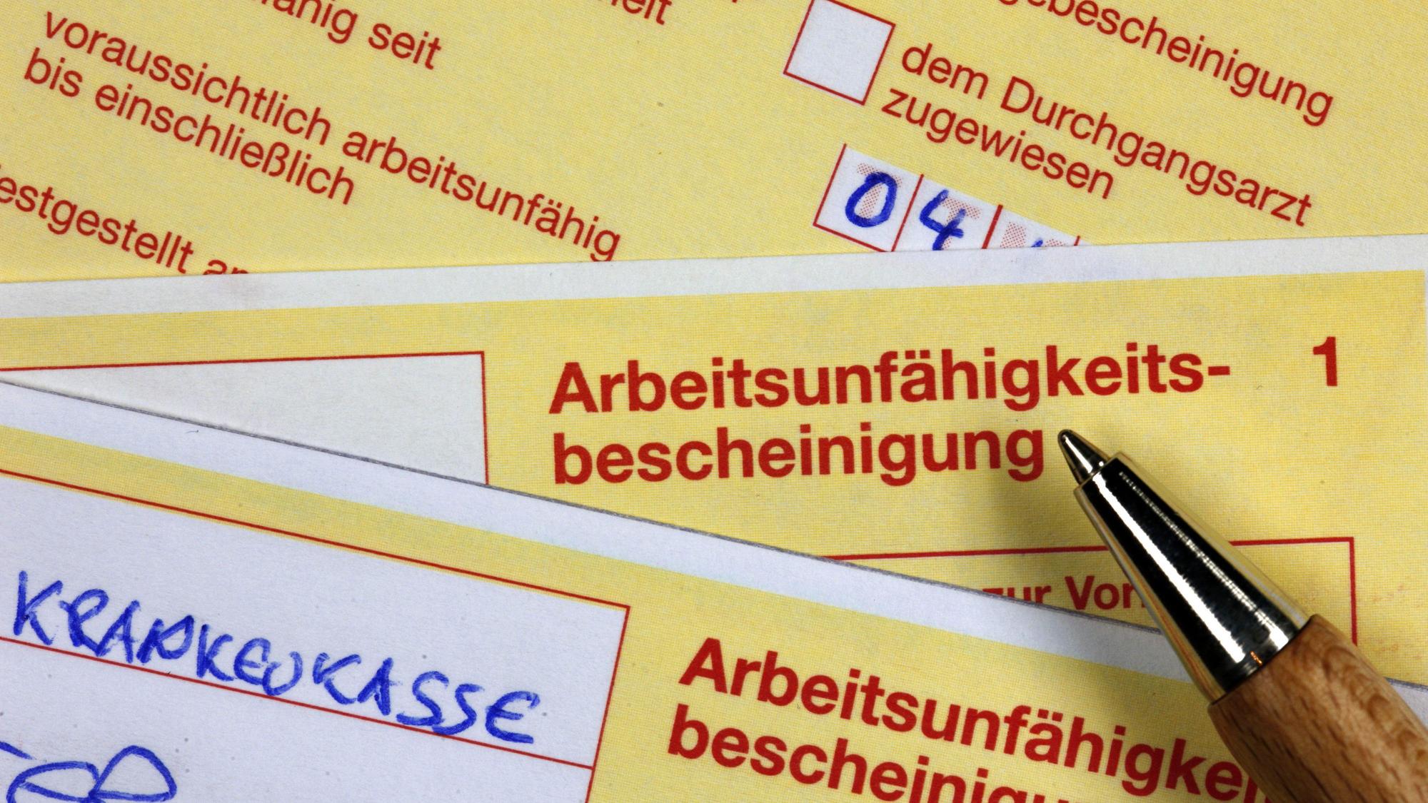 Ein Stift liegt auf einer Arbeitsunfähigkeitsbescheinigung.