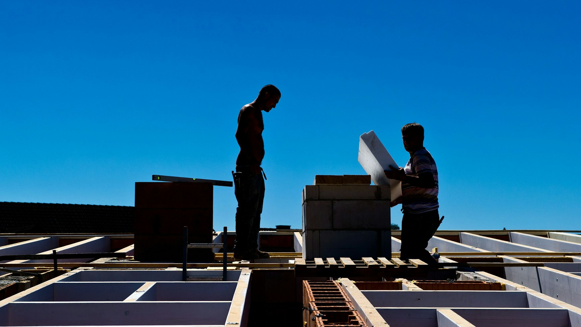 Bauarbeiter stehen am 01.08.2013 in Untergruppenbach (Baden-Württemberg) auf der Baustelle eines Hauses auf dem Dach. Die baden-württembergische Bauwirtschaft hat sich im ersten Halbjahr vom negativen Bundestrend abgekoppelt. Foto: Daniel Bockwoldt/dpa (zu dpa «Baukonjunktur im Südwesten legt leicht zu» vom 05.09.2013) ++ +++ dpa-Bildfunk +++